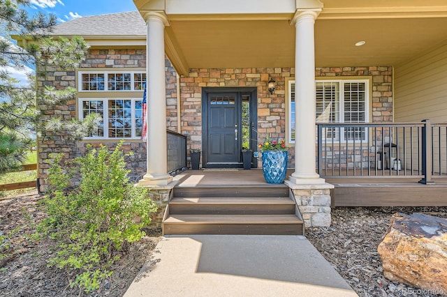doorway to property featuring stone siding and covered porch