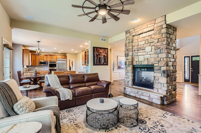 living room featuring ceiling fan, wood finished floors, a fireplace, and recessed lighting