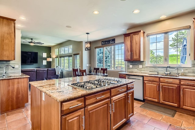 kitchen with stainless steel appliances, backsplash, open floor plan, a sink, and recessed lighting