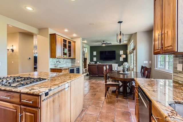 kitchen with appliances with stainless steel finishes, ceiling fan, tasteful backsplash, recessed lighting, and light stone countertops