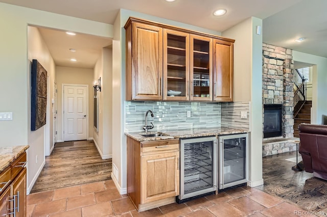 indoor wet bar featuring wine cooler, backsplash, baseboards, stairway, and recessed lighting
