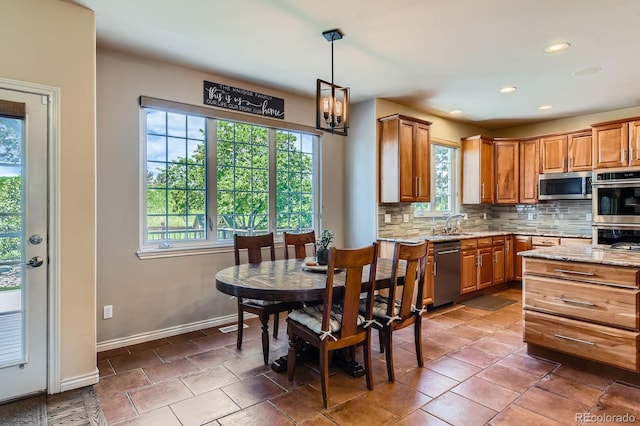 dining space featuring healthy amount of natural light, recessed lighting, baseboards, and a chandelier