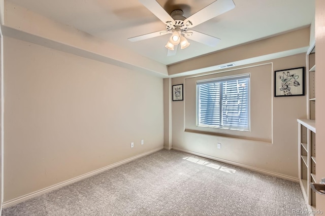 carpeted spare room featuring baseboards and ceiling fan