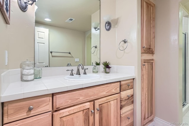 bathroom with vanity and a shower with shower door