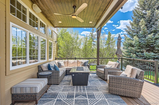 wooden terrace with an outdoor living space and ceiling fan