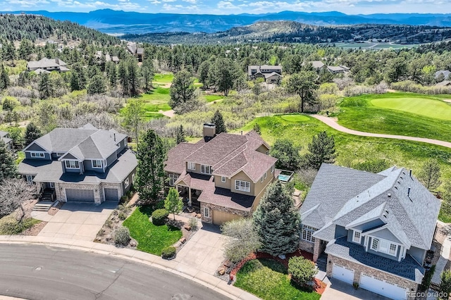 aerial perspective of suburban area with a mountainous background and a golf course