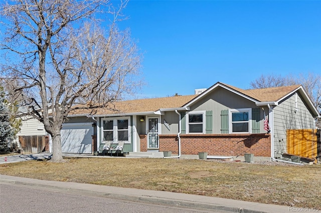 single story home featuring an attached garage, a front yard, fence, and brick siding