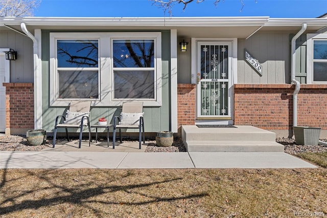 doorway to property featuring brick siding