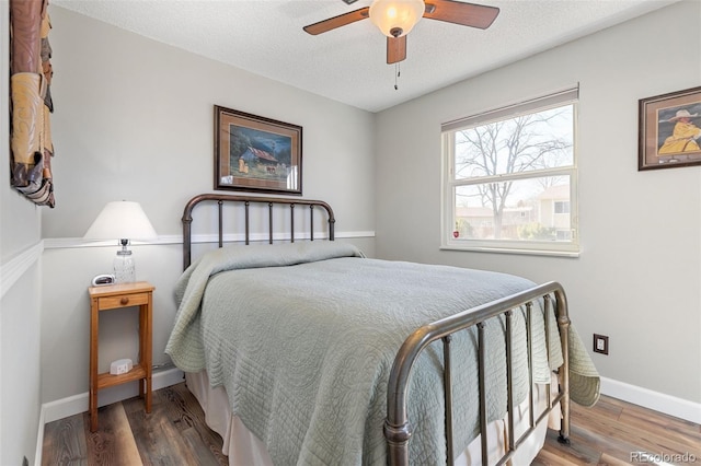 bedroom with a textured ceiling, ceiling fan, wood finished floors, and baseboards