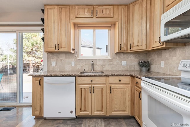 kitchen featuring tasteful backsplash, light brown cabinets, a sink, light stone countertops, and white appliances