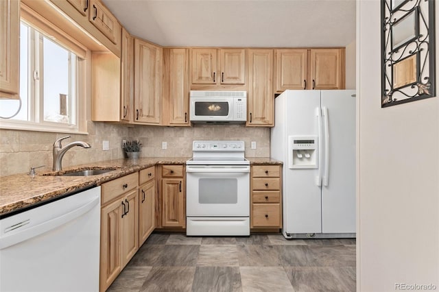 kitchen featuring white appliances, tasteful backsplash, light brown cabinets, and a sink