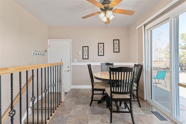 dining space with ceiling fan, visible vents, and baseboards