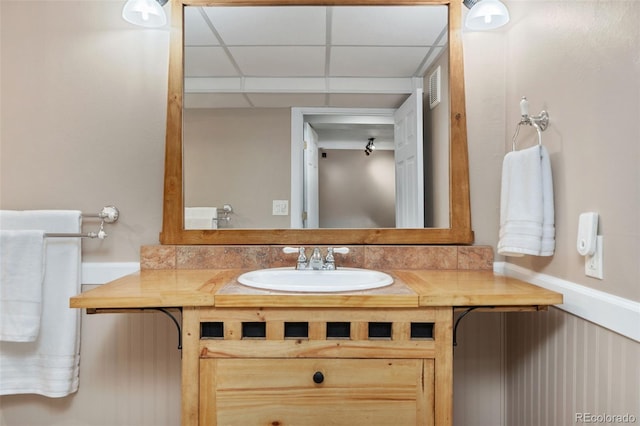 bathroom with visible vents, a drop ceiling, and vanity