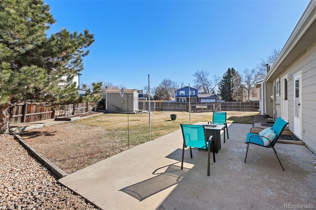 view of patio featuring a fenced backyard, an outdoor structure, and a storage unit