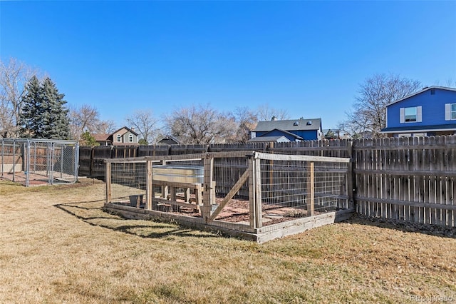 view of yard featuring a fenced backyard, exterior structure, and an outbuilding