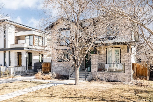 view of front facade with stone siding and fence