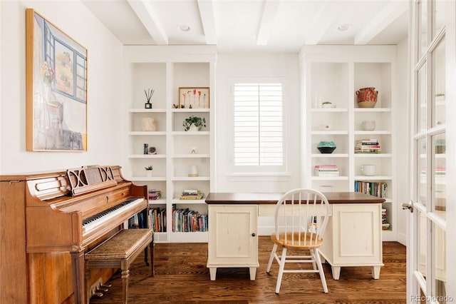 office with built in shelves and dark wood-type flooring