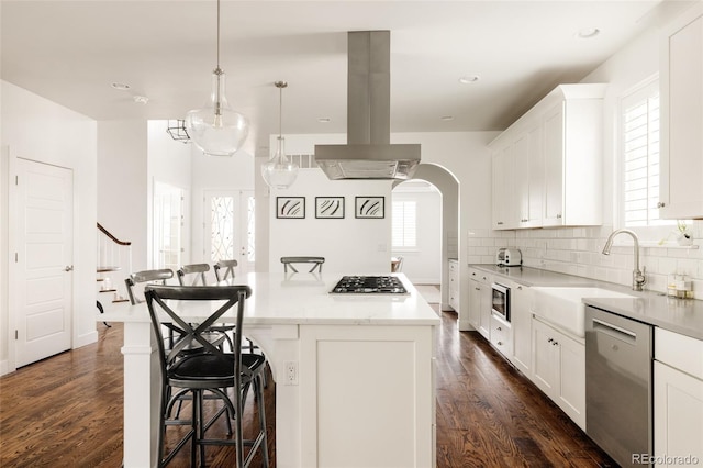 kitchen featuring a breakfast bar area, dark wood-style floors, a kitchen island, island exhaust hood, and stainless steel appliances