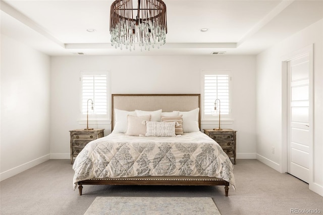 bedroom featuring carpet flooring, a raised ceiling, multiple windows, and visible vents