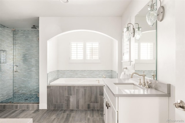 full bath featuring a bath, a shower stall, and vanity