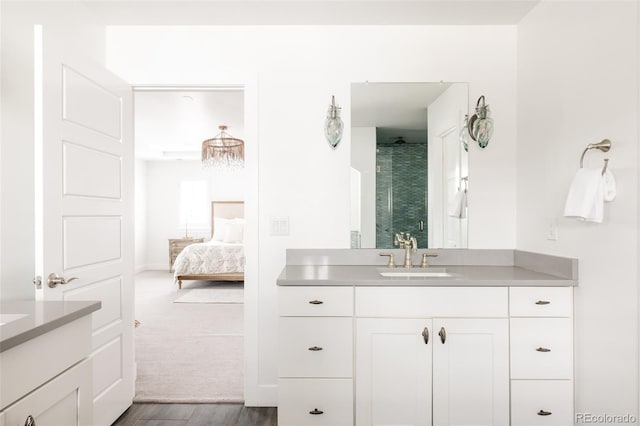 bathroom with vanity, a shower stall, wood finished floors, and ensuite bathroom