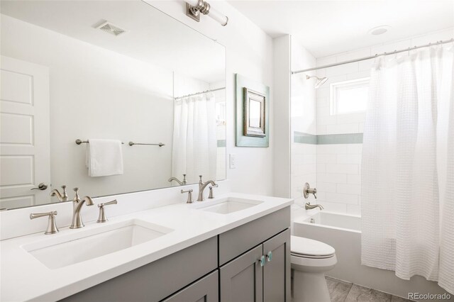 full bath with a sink, visible vents, toilet, and shower / tub combo with curtain