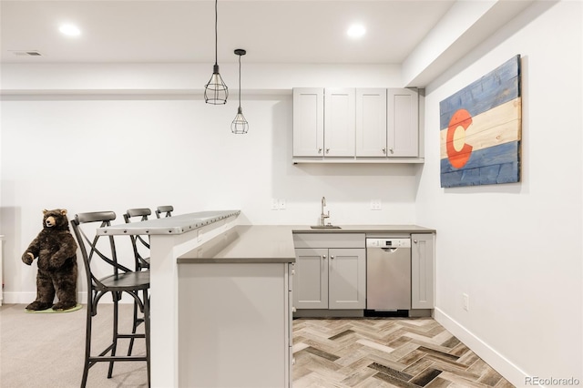 kitchen with visible vents, pendant lighting, a peninsula, stainless steel dishwasher, and a sink