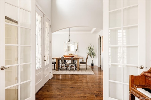 entryway with french doors, arched walkways, and dark wood-style flooring