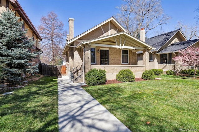 view of front of home with a chimney and brick siding