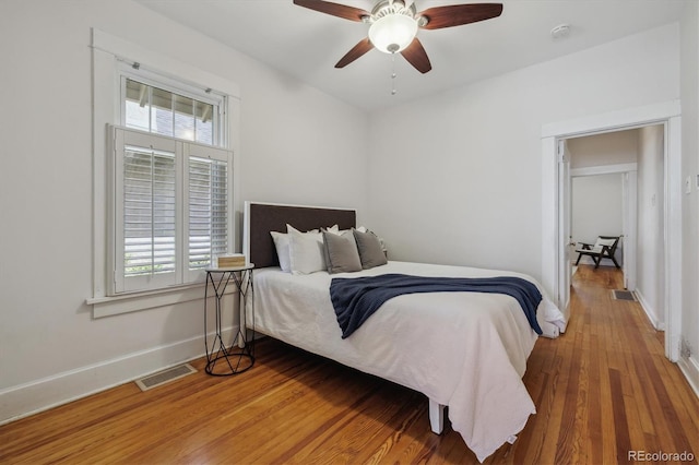 bedroom featuring wood finished floors, baseboards, and ceiling fan