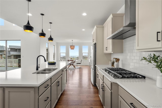 9566 Poppy Way, Arvada, CO 80007 - kitchen with wall chimney range hood, appliances with stainless steel finishes, light countertops, dark wood-type flooring, and recessed lighting