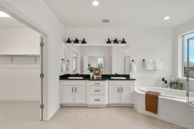 9566 Poppy Way, Arvada, CO 80007 - bathroom featuring double vanity, a garden tub, a spacious closet, recessed lighting, and tile patterned floors