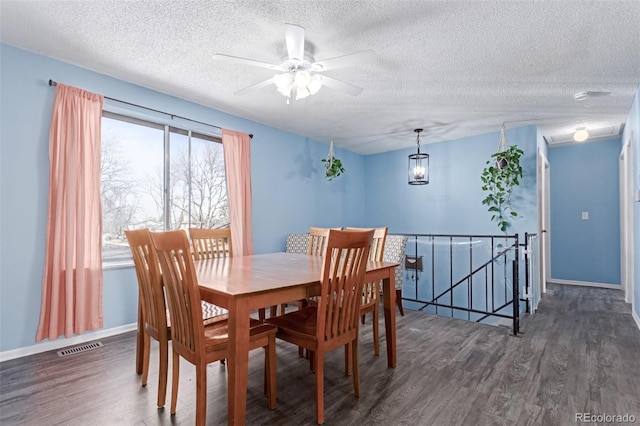 dining area with wood finished floors, visible vents, and a textured ceiling