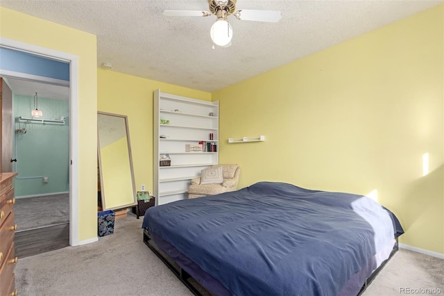 bedroom featuring ceiling fan, a textured ceiling, baseboards, and carpet floors