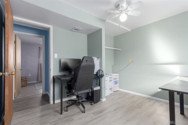 office space with visible vents, wood finished floors, baseboards, and ceiling fan