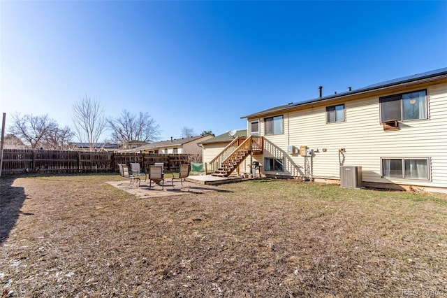 rear view of house with a yard, a patio area, central AC, and fence private yard