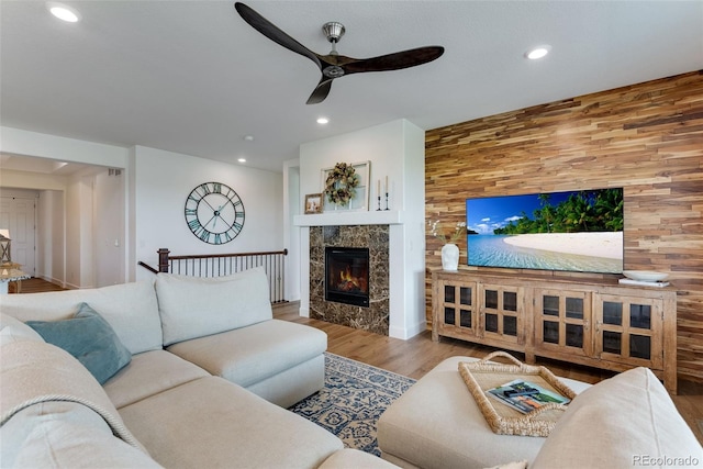 11817 Phoebe St, Parker, CO 80134 - living room featuring ceiling fan, wood finished floors, wooden walls, recessed lighting, and a fireplace