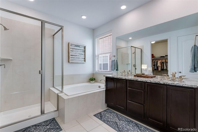 11817 Phoebe St, Parker, CO 80134 - bathroom featuring a shower stall, tile patterned flooring, a garden tub, double vanity, and a spacious closet