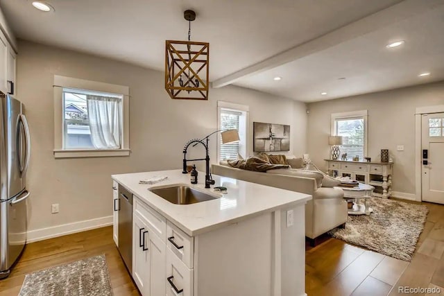 5123 W 41st Ave, Denver, CO 80212 - kitchen featuring appliances with stainless steel finishes, healthy amount of natural light, wood finished floors, white cabinetry, and recessed lighting