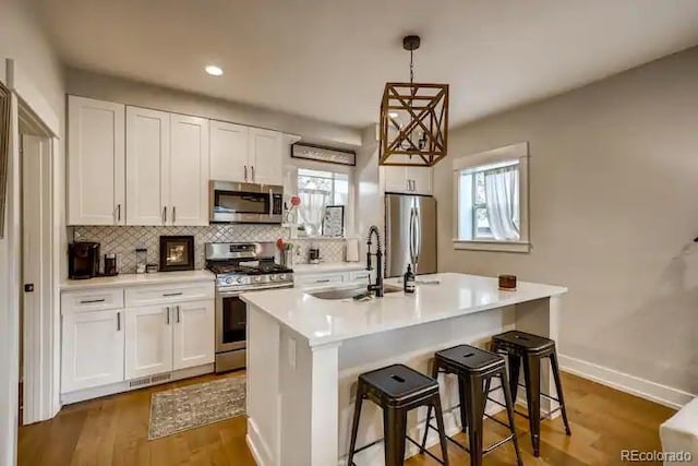 5123 W 41st Ave, Denver, CO 80212 - kitchen featuring stainless steel appliances, decorative backsplash, white cabinetry, light countertops, and recessed lighting