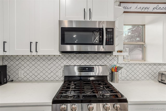 5123 W 41st Ave, Denver, CO 80212 - kitchen featuring appliances with stainless steel finishes, white cabinetry, tasteful backsplash, and light stone counters