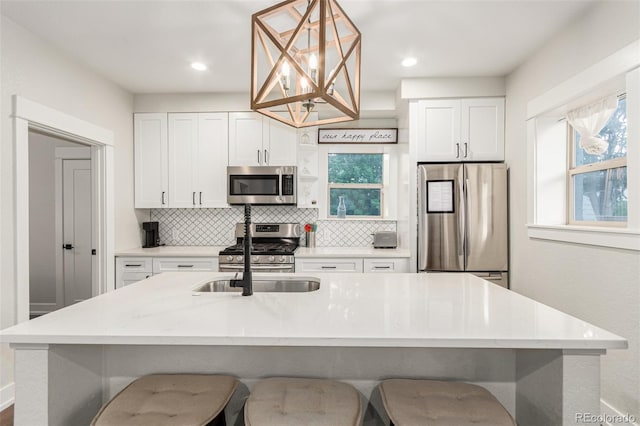 5123 W 41st Ave, Denver, CO 80212 - kitchen featuring stainless steel appliances, decorative backsplash, white cabinetry, a kitchen breakfast bar, and recessed lighting