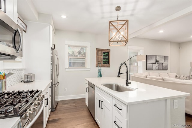 5123 W 41st Ave, Denver, CO 80212 - kitchen featuring appliances with stainless steel finishes, dark wood-style floors, open floor plan, a kitchen island with sink, and white cabinetry