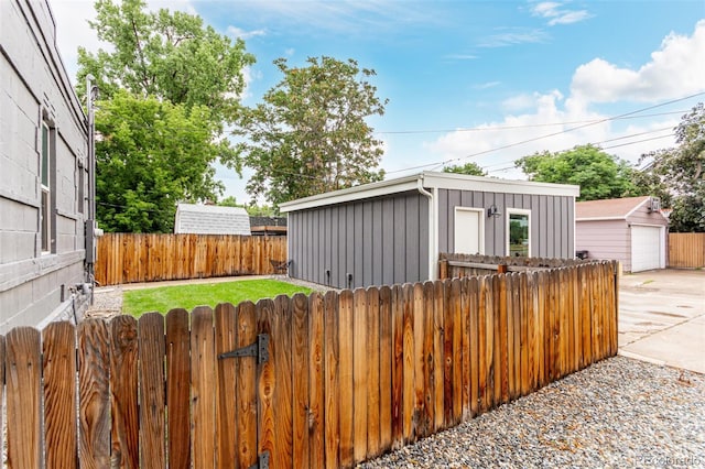 5123 W 41st Ave, Denver, CO 80212 - view of front of property featuring board and batten siding, an outdoor structure, concrete driveway, and a detached garage