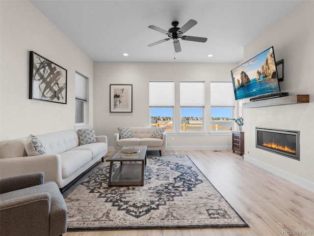 living room with ceiling fan and light wood-type flooring