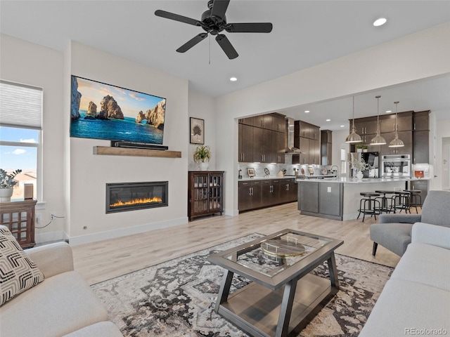 living room featuring ceiling fan and light hardwood / wood-style flooring