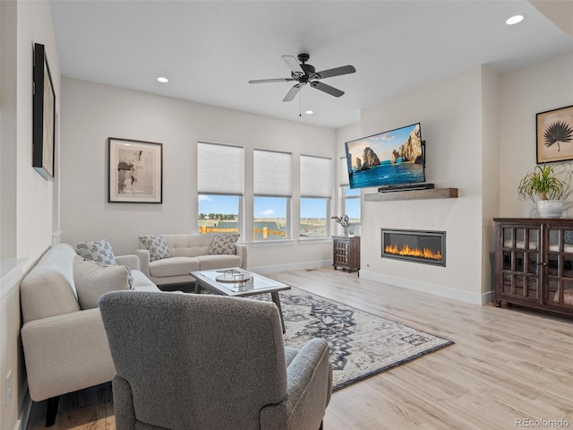 living room featuring ceiling fan and light hardwood / wood-style floors