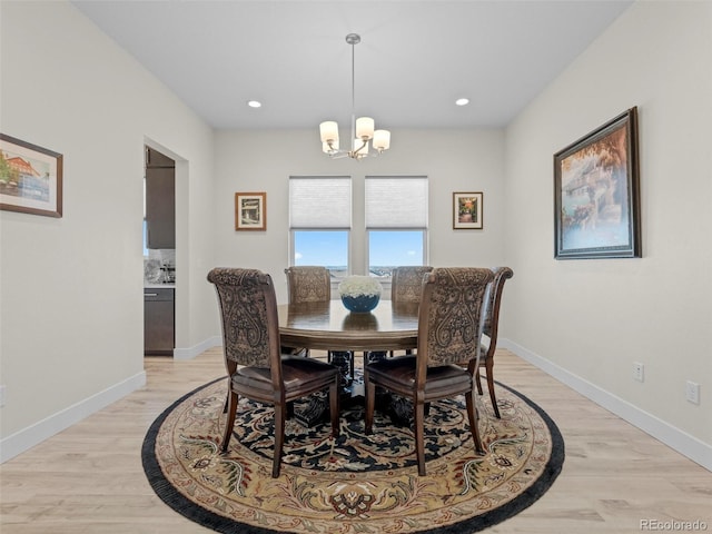 dining space with light hardwood / wood-style flooring and a chandelier