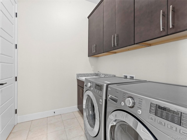 laundry room with washer and dryer, cabinets, light tile patterned floors, and sink