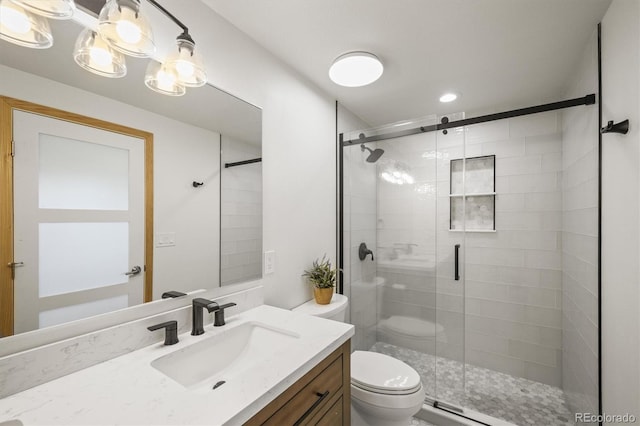 bathroom featuring a shower stall, toilet, and vanity